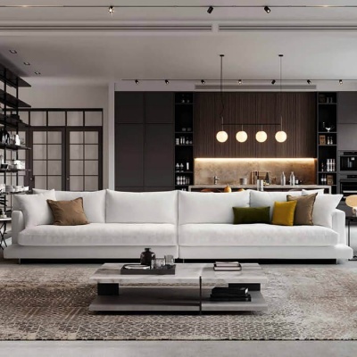 Sofá branco grande com almofadas coloridas em sala com cozinha escura ao fundo