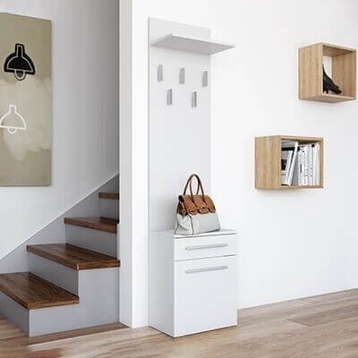 Móvel de entrada branco com mala castanha e bege, escada ao lado e prateleiras de madeira clara na parede