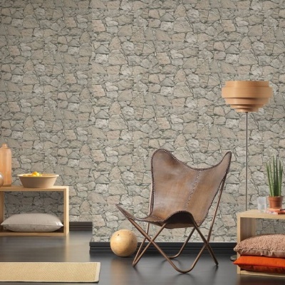 Sala com cadeira de pele castanha, papel de parede de pedras, prateleiras de madeira clara e candeeiro de pé.