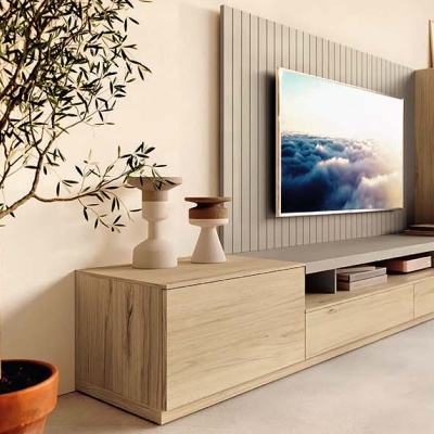 Móvel TV em madeira clara com castiçais, planta em vaso terracota, painel ripado cinza e televisão com imagem de nuvens