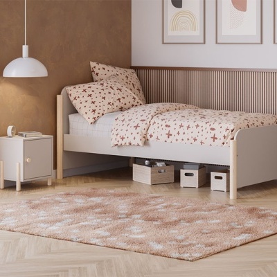 Quarto com cama individual cinza clara com roupa de cama estampada e mesa de cabeceira cinza clara com candeeiro branco