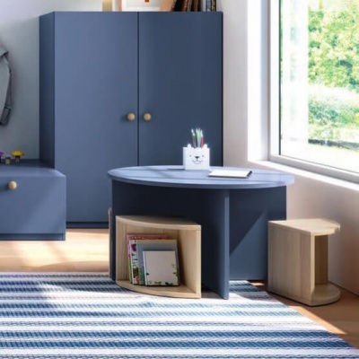 Mesa oval azul com compartimentos de arrumação em madeira clara e bancos, perto de armário azul e janela