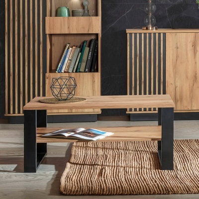 Mesa de centro em madeira clara e preto sobre tapete bege, com móveis e prateleira ao fundo