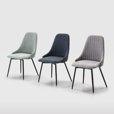 Três cadeiras estofadas em tecido verde claro, azul escuro e cinzento, com pernas pretas sobre fundo neutro