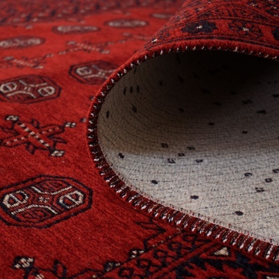 Tapete vermelho com padrões geométricos e frente dobrada