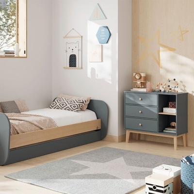 Quarto infantil com cama, cómoda cinza, tapete com estrelas e decoração nas paredes