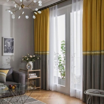 Cortinas bicolores amarelo e cinza na sala com sofá cinza e móveis modernos