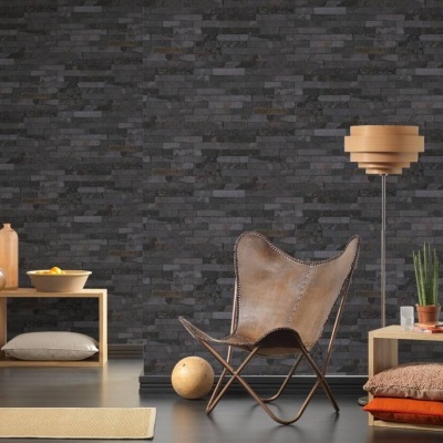 Sala com cadeira de couro castanho butterfly, parede de tijolo escuro, candeeiro de pé madeira, estante com livros e almofadas