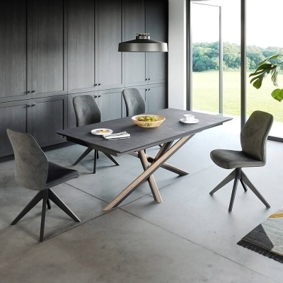 Conjunto de mesa de jantar cinza escuro com pernas de madeira e três cadeiras estofadas cinza numa sala moderna