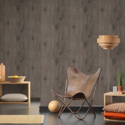 Cadeira de pele castanha e móveis baixos de madeira clara em ambiente com parede de madeira cinzenta