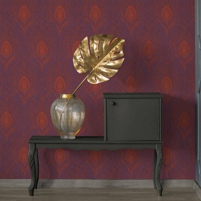 consola preta com vaso de vidro e folha dourada frente a papel de parede vermelho e roxo