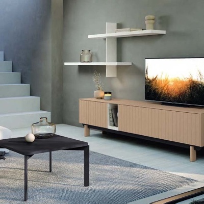 Sala de estar moderna com sofá branco, mesa de centro preta, móvel de TV de madeira clara e escada cinzenta.