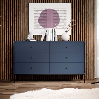 Cómoda azul escura com seis gavetas e decoração sobre a tampa