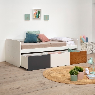 Cama branca com gavetas coloridas e almofadas em quarto moderno