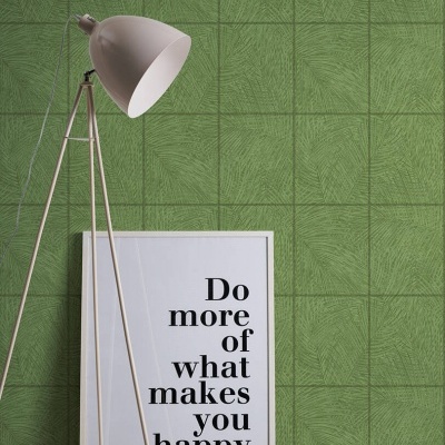 Lâmpada de chão branca com tripé metálico junto a moldura branca com texto numa parede verde texturada