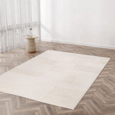 Tapete bege claro com padrões geométricos em relevo sobre chão de madeira, mesa de pedra clara com garrafa e copos ao lado, parede branca