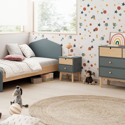 Quarto infantil com mobília azul e bege, tapete redondo e papel de parede colorido