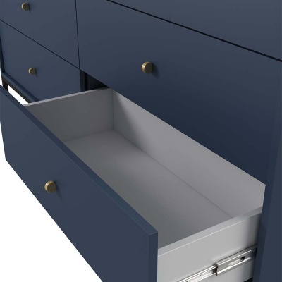 Cômoda azul com gaveta aberta e puxadores dourados