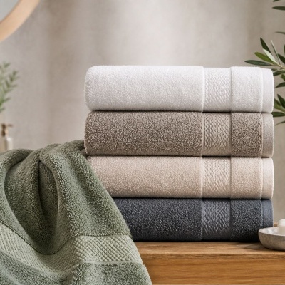 Conjunto de toalhas em cores variadas com dispenser de sabão e sabonete num ambiente de casa de banho
