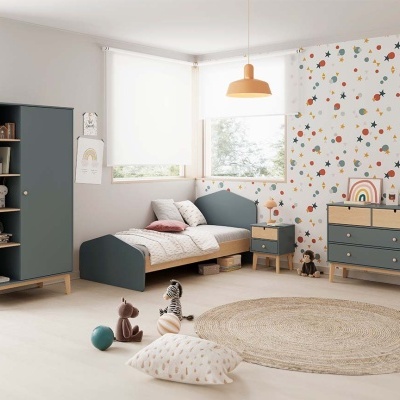 Quarto infantil com móveis em madeira cinza e natural, papel de parede colorido e tapete redondo de juta.