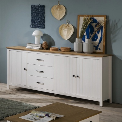 Aparador branco com tampo de madeira clara decorado com lâmpada, livros, vasos e quadro azul