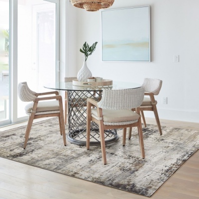 Mesa de jantar redonda em vidro com cadeiras de madeira e vime branco sobre tapete bege e cinza