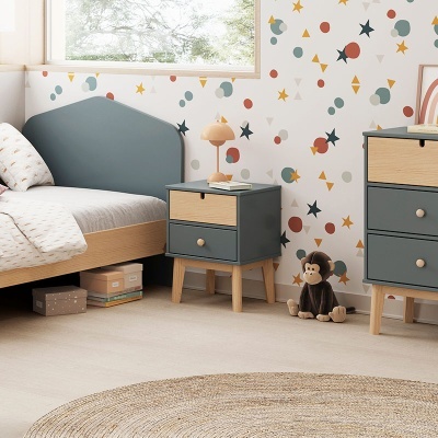 Quarto infantil com mobília cinza e madeira, papel de parede colorido, brinquedo de macaco e tapete redondo