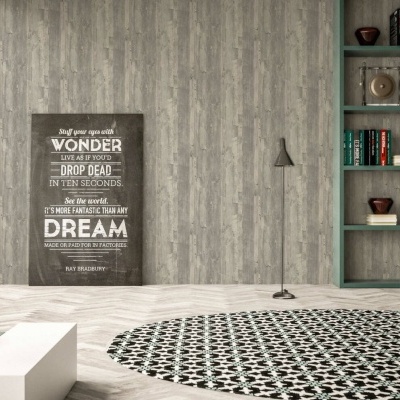 Póster de texto em inglês encostado em parede cinza claro com padrão madeira, tapete preto e branco e estante com livros e objetos decorativos