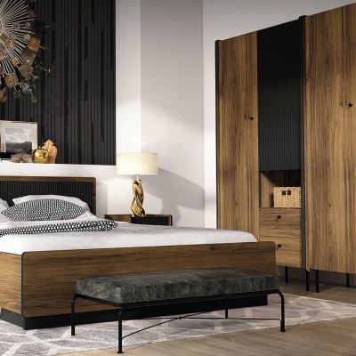 Quarto moderno com mobiliário em madeira escura, banco cinza e abajur dourado