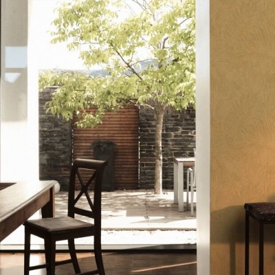 Sala com mesa e cadeira de madeira e vista para pátio exterior com árvore