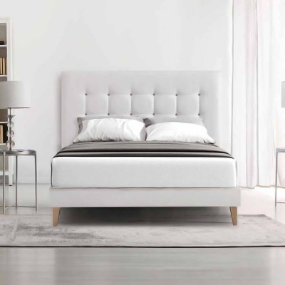 Cama de casal branca com cabeceira estofada e roupa de cama branca e cinzenta