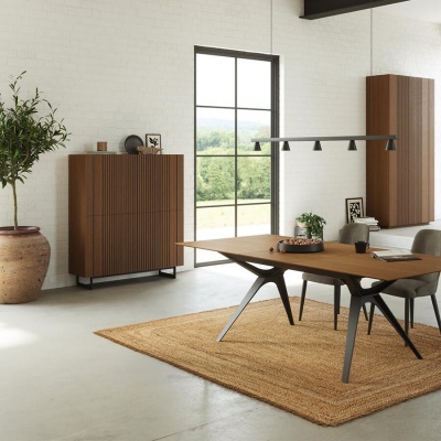 Sala com mesa e cadeiras em madeira e tecido cinza, tapete natural e armários de madeira marrom sobre parede branca com janela