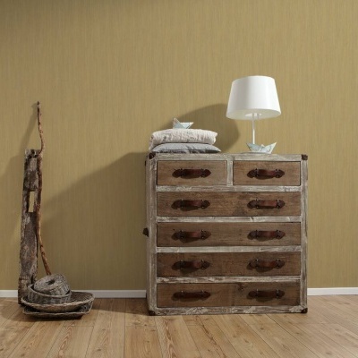 Cômoda de madeira envelhecida com cinco gavetas e um candeeiro branco em cima