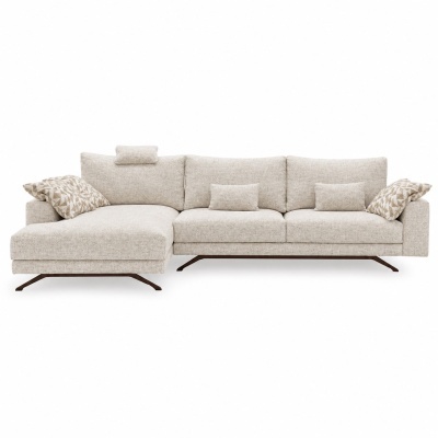 Sofá chaise longue de tecido bege claro com almofadas decorativas e pés metálicos escuros.