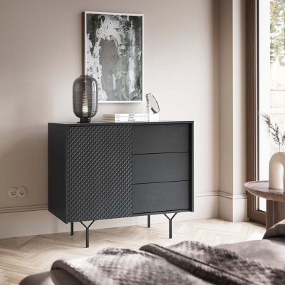 Cómoda preta com porta texturizada e três gavetas em sala clara com decoração moderna