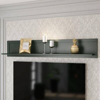 Prateleira preta de parede com moldura dourada, velas e figura de ananás em fundo de papel de parede cinzento com padrão.