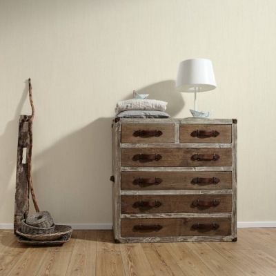 Móvel vintage de madeira com gavetas, lâmpada de mesa branca e suporte rústico com corda