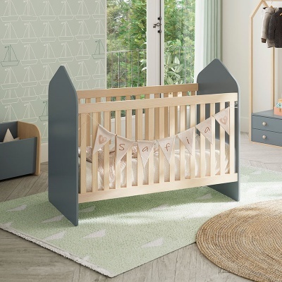 Berço de bebé em madeira clara e cinza com bandeirolas 'Safira' em quarto decorado em verde e madeira.