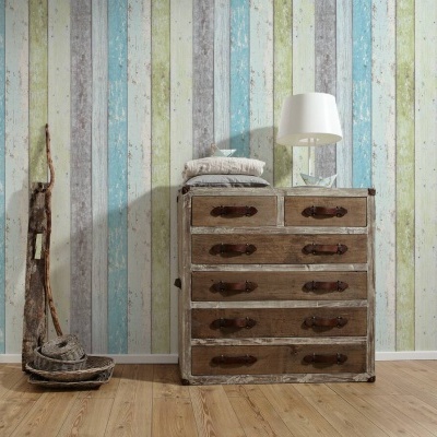 Cómoda rústica de madeira envelhecida contra parede listrada colorida com lâmpada branca em cima