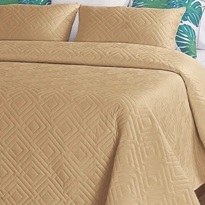 Colcha e fronhas bege com padrão geométrico em cama com almofadas decorativas verdes e azuis