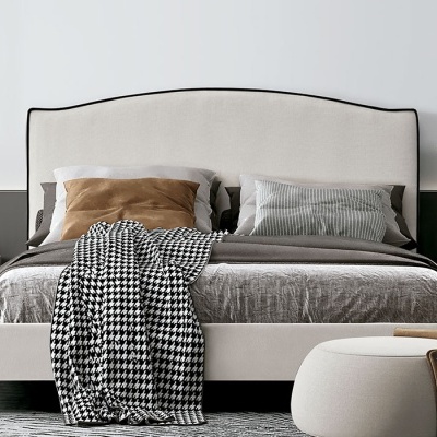 Quarto moderno com cama estofada bege, mesas de cabeceira pretas, poltrona castanha e decoração minimalista