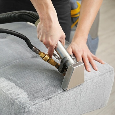 Limpeza de estofado cinzento com aparelho metálico a vapor