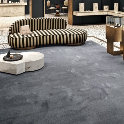 sofá riscado preto e bege, mesa de centro branca, tapete cinzento, loja de joias