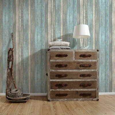 Cómoda vintage de madeira com tecidos e candeeiro sobre chão de madeira clara e parede de painéis verticais coloridos