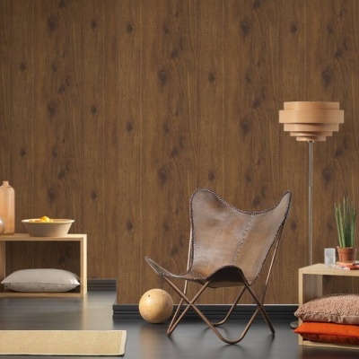 Cadeira em pele castanha com estrutura metálica num ambiente com paredes de madeira escura e mesas baixas de madeira clara com objetos decorativos