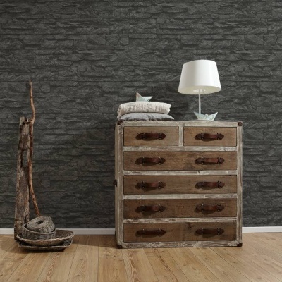 Cómoda rústica de madeira com gavetas e puxadores de couro, lâmpada branca, almofadas, parede de pedra escura e chão de madeira clara