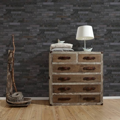 Móvel rústico com seis gavetas, lâmpada branca e almofadas, parede de tijolos escuros e chão de madeira clara