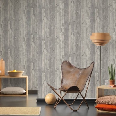 Cadeira de pele castanha e candeeiro de pé num ambiente moderno com decoração em madeira e parede cinzenta.