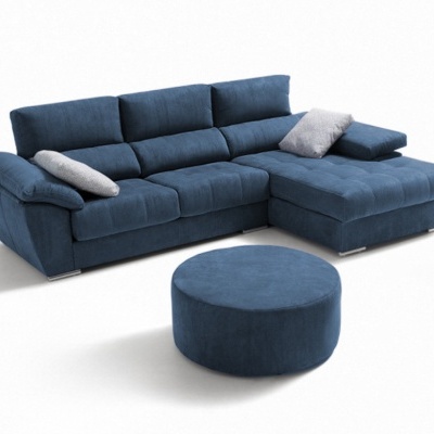 Sofá chaise longue azul com pufe redondo e duas almofadas cinza em fundo branco