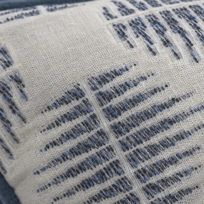 Almofada com padrões verticais e diagonais em tons de azul e cinzento